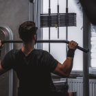 Back view of a man exercising with lat pulldown machine in the gym.